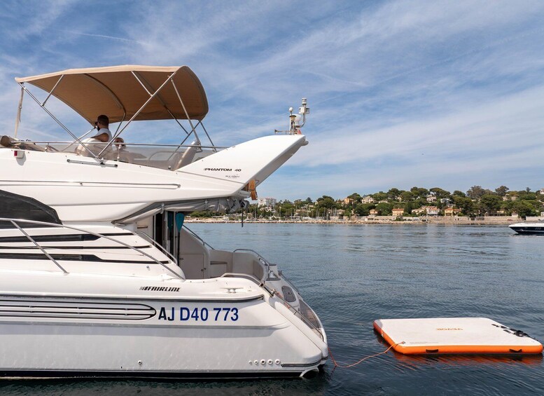 Un yacht blanc, baptisé « Fairline Phantom 40 », était amarré dans une marina, avec une ville côtière en arrière-plan. 3