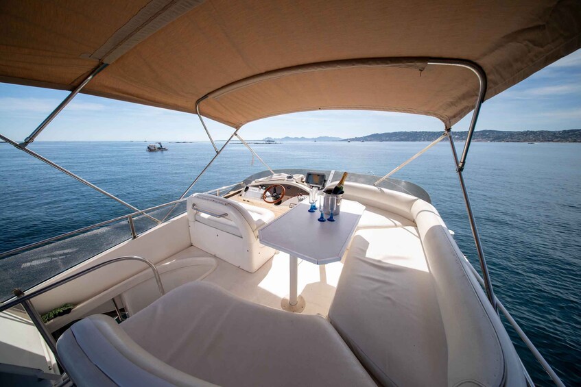 L'intérieur d'un bateau, avec une table, des sièges rembourrés et une vue sur la mer. 4