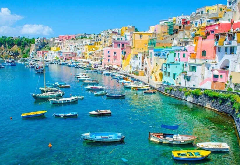 A coastal town with colorful buildings and numerous boats docked along the waterfront. 1