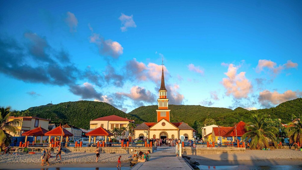 A coastal town with a prominent church, beach, and surrounding hills. 1