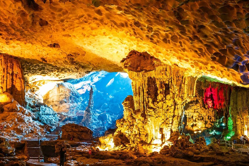 A cave with stalactites, a blue illuminated cavern, and a staircase. 5