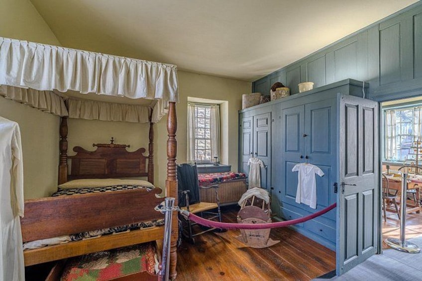 Une chambre à coucher avec un lit à baldaquin, une armoire en bois et une petite table avec une chaise. 5