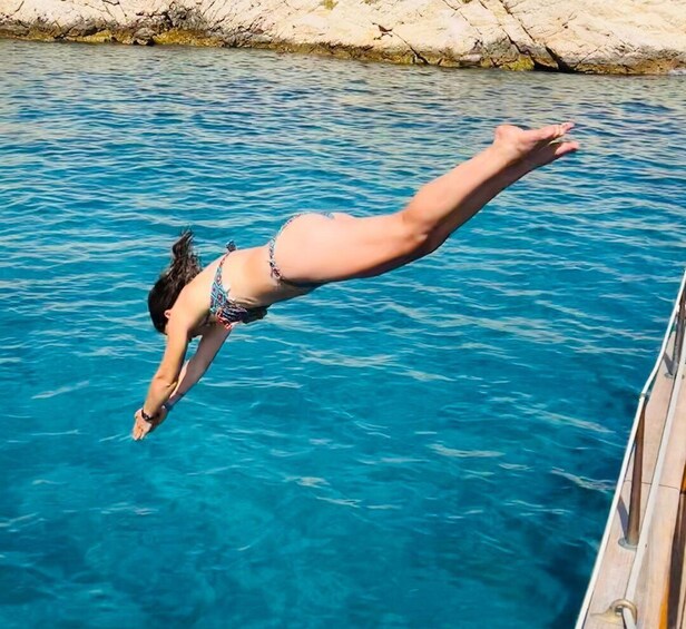 A person diving into clear blue water from a dock. 2