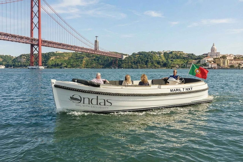 A boat named 'Ondas' with 'MARIL 7 NXT' on the side, sailing on water with a bridge and a building in the background. 1