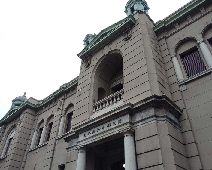 A classical building with arched windows and a sign in a foreign language. 4