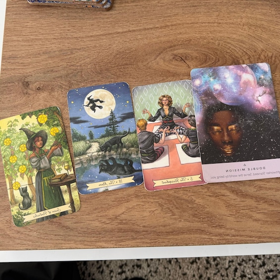 Four tarot cards on a wooden surface. 2