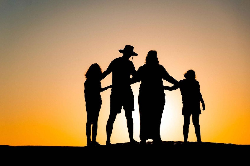 Eine Silhouette einer Familie vor einem Sonnenuntergangshimmel. 1