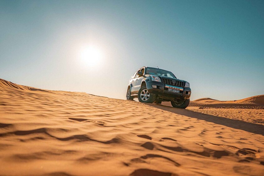 A vehicle on a sandy terrain with a clear sky. 4