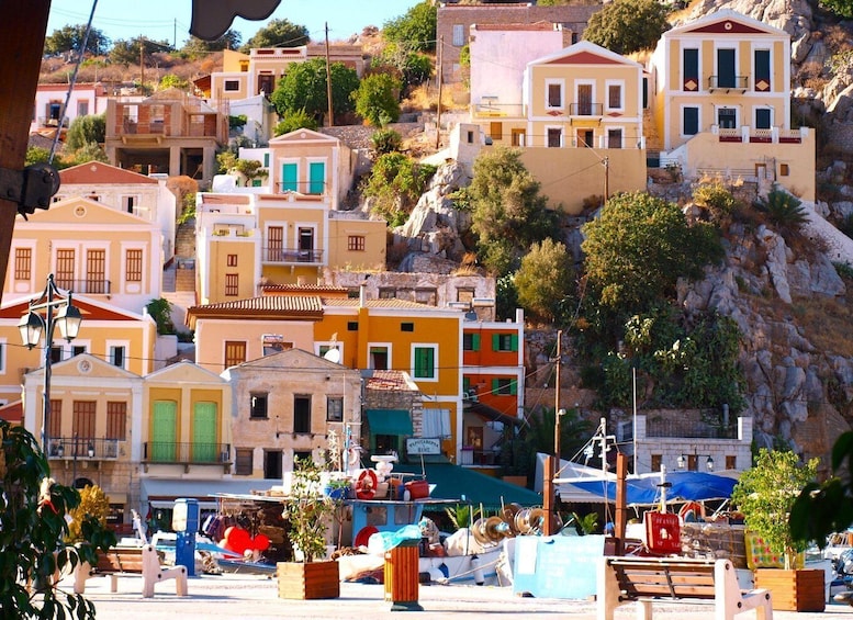 A coastal village with colorful buildings, a rocky hillside, and boats docked at the waterfront. 2