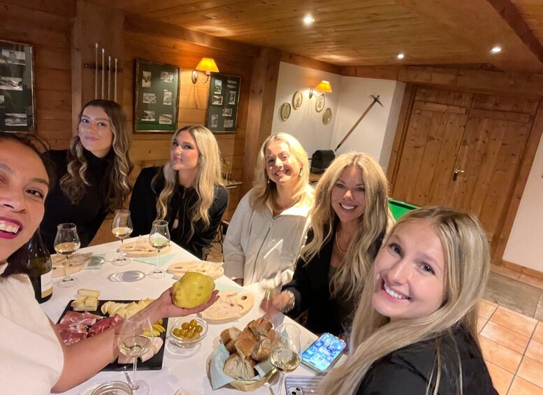 A group of people dining at a wooden interior restaurant with a table set with food and wine glasses. 5