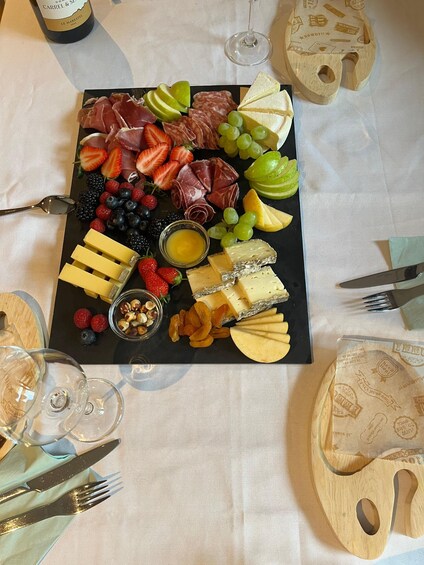 A charcuterie board with various cheeses, fruits, and nuts. 4