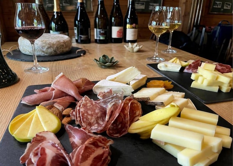A charcuterie board with various meats, cheeses, and fruits, accompanied by wine bottles and glasses. 1