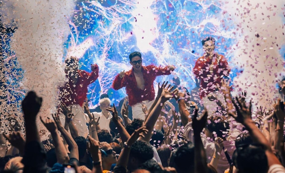 A crowd at a concert with confetti falling. 2