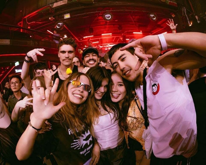 A group of people in a dimly lit venue with red lighting. 1