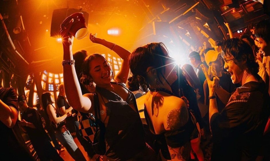 A crowded indoor event with people holding up lighted objects. 3