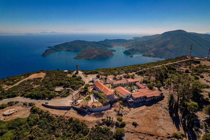 An aerial view of a coastal area with buildings, a lighthouse, and a clear view of the sea and islands. 5