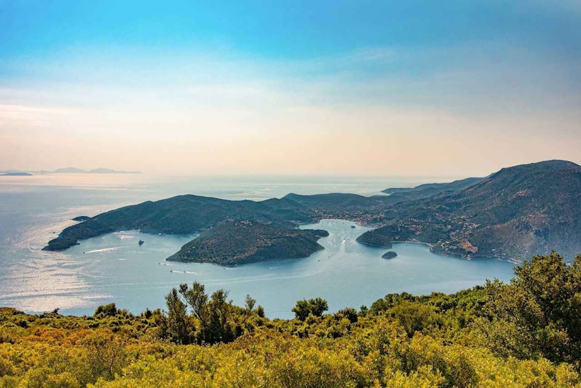 A coastal landscape with a bay, hills, and a clear sky. 1