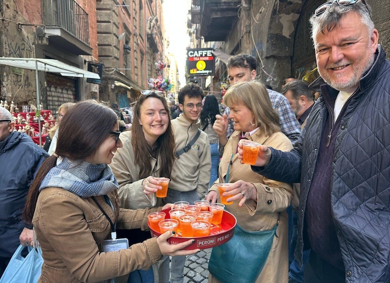 A street scene with people holding drinks and a tray of orange beverages. 4