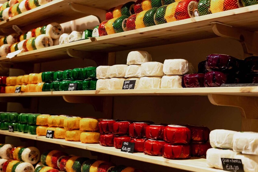 Shelves stocked with various cheeses and cured meats, each with a price tag. 4