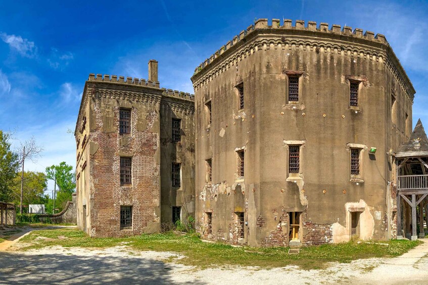 An old, weathered building with brick and concrete walls, a turret, and a small tower. 3