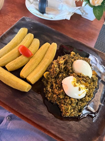 A plate with fried dough sticks, a tomato slice, and a dish with greens and eggs. 2