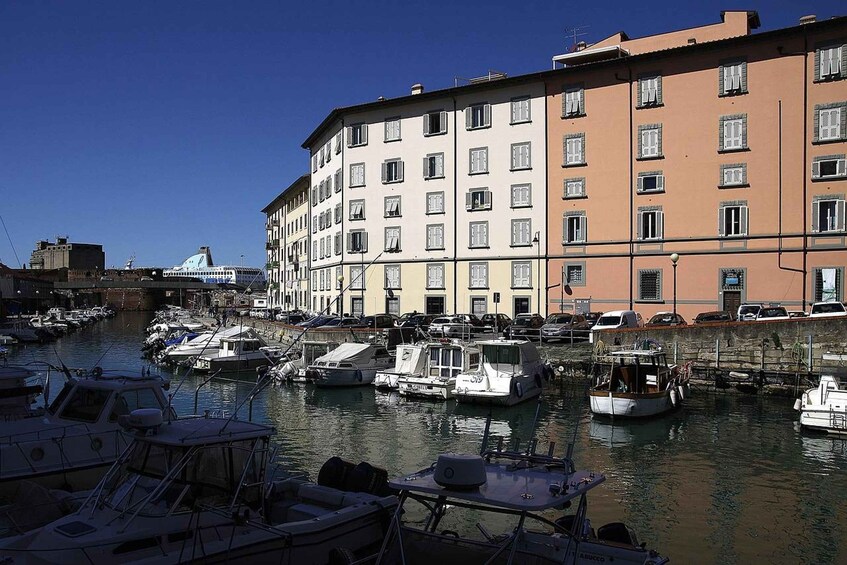 A marina with boats docked, a bridge in the background, and multi-story buildings along the waterfront. 4