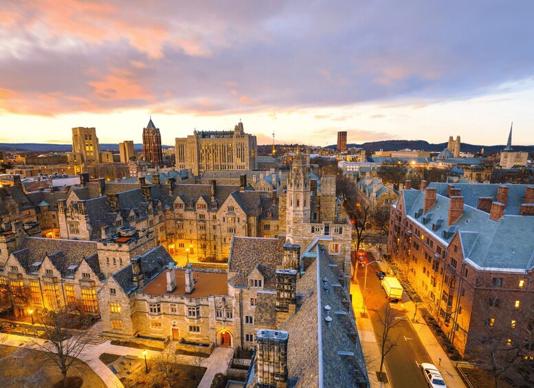 A cityscape at dusk with historic buildings and a prominent tower. 5
