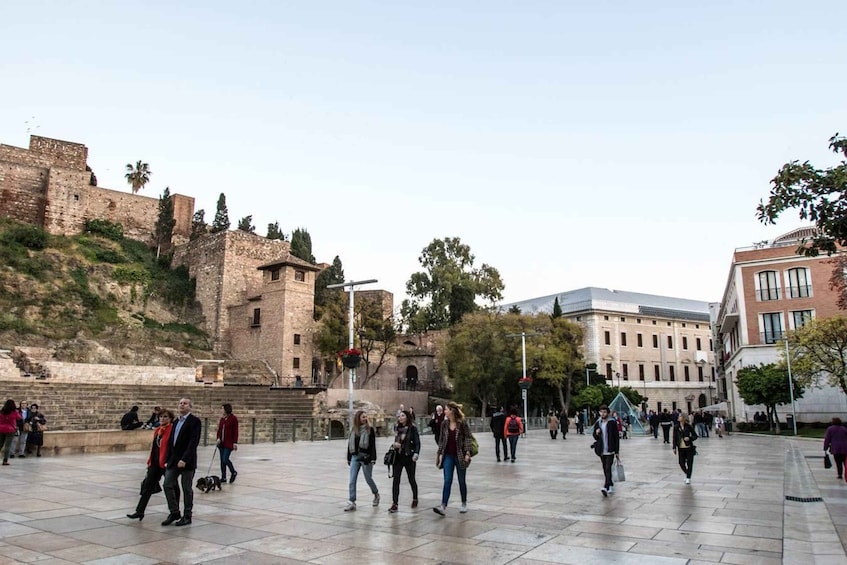 A historical site with ancient ruins and modern buildings. 1
