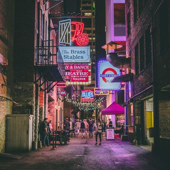 A neon-lit street with signs for The Brass Stables, Y & Dance Theatre, and Fleet Street Pub. 1
