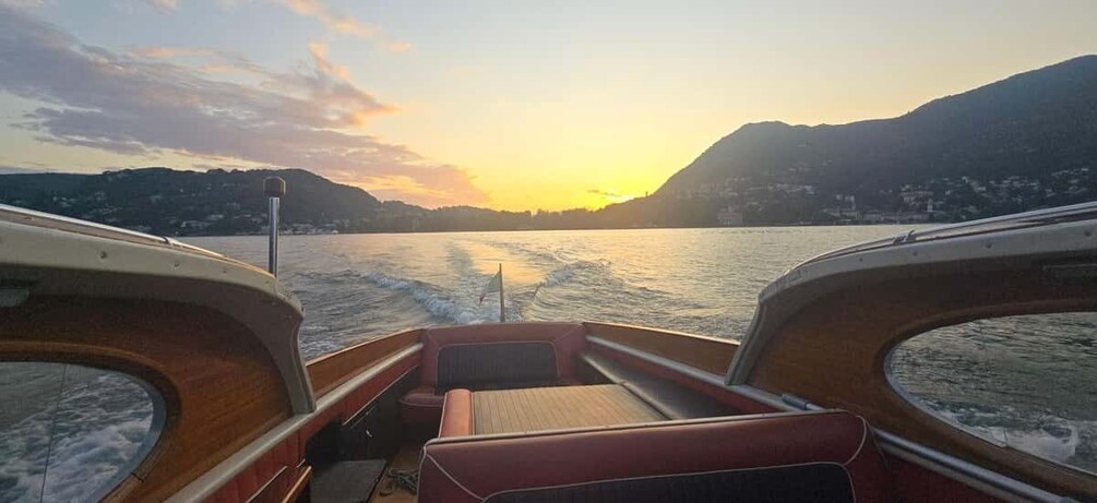 A boat on a calm lake with mountains in the background during sunset. 4