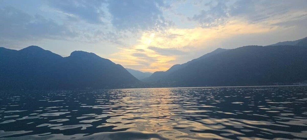 A calm lake with mountains in the background and a sunset sky. 5