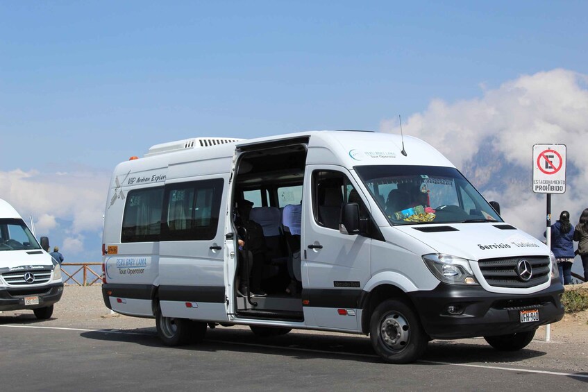 A white Mercedes-Benz van with the text 'VIP Anthon Explorer' and 'Peru Baby Llama Tour Operator' on the side, parked on a road with a no parking sign in the background. 3