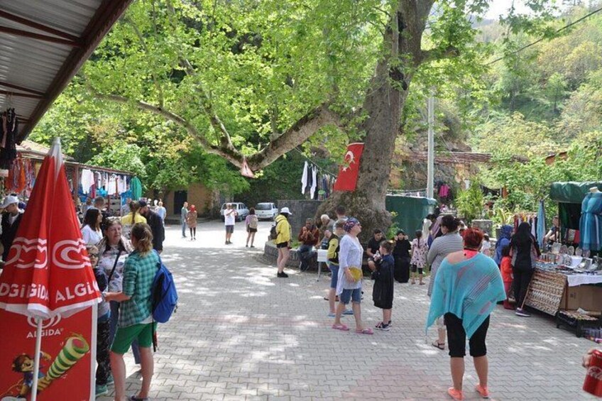 A crowded outdoor market with people walking and vendors selling goods. 3