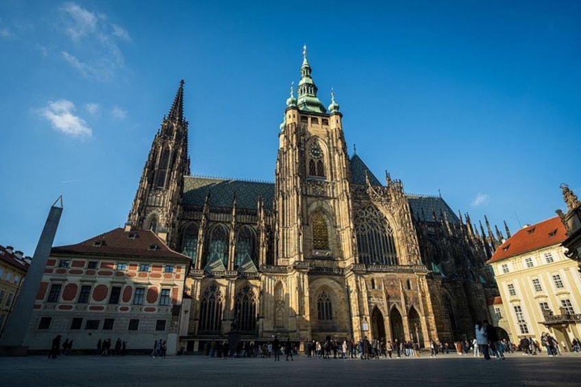 En historisk katedral med en detaljerad och vacker arkitektur, ett framträdande klocktorn och en klarblå himmel. 1