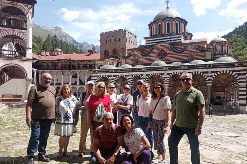 A group of people in front of a historic building with arches and domes. 2