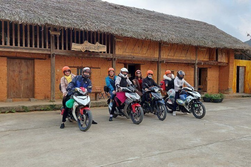 Un groupe de personnes à moto était garé devant un bâtiment rustique dont le toit était recouvert de chaume. 1