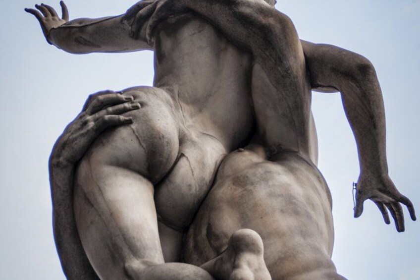 A sculpture of a reclining human figure with outstretched arms and one leg bent. 5