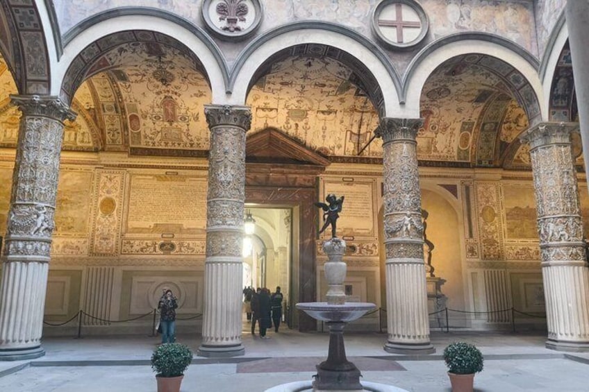 Un patio ornamentado con columnas, una fuente y una estatua. 5