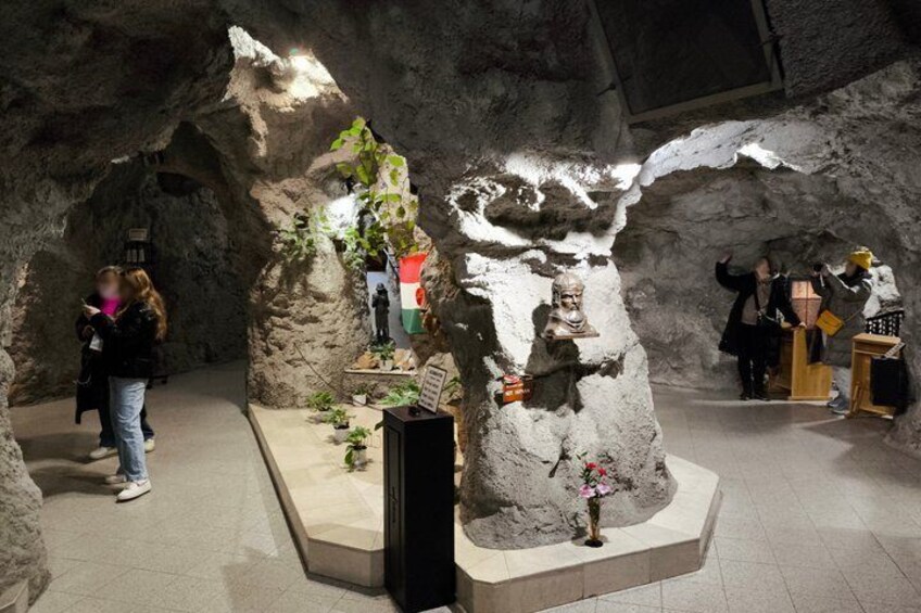 Une exposition dans une grotte présentant des formations rocheuses, une statue et un podium. 5