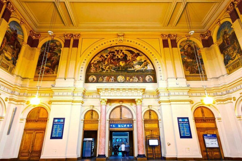 An ornate building with a large arched entrance, detailed frescoes, and classical architectural elements. 3