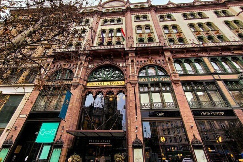 Un bâtiment historique à l’architecture riche et élaborée, dont l’entrée principale est marquée de l’inscription « PARISI UDVAR ». 3