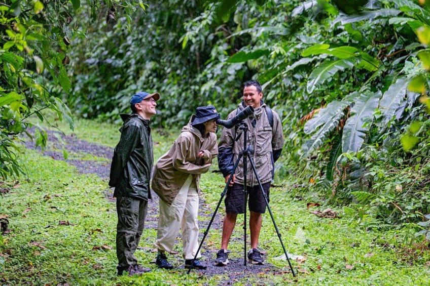 Three people in a forested area, one with a camera on a tripod. 5