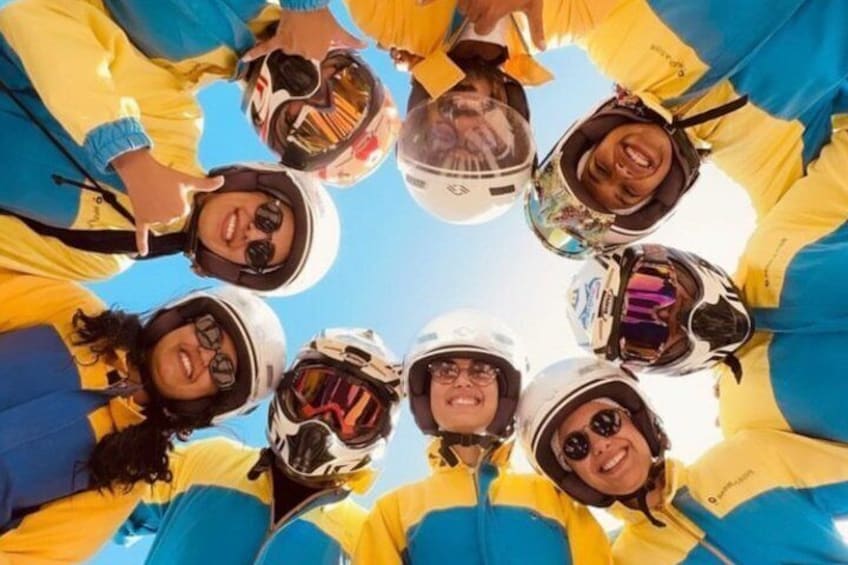 Un groupe de personnes, vêtues de vestes et de casques jaunes et bleus, regardent le ciel. 1