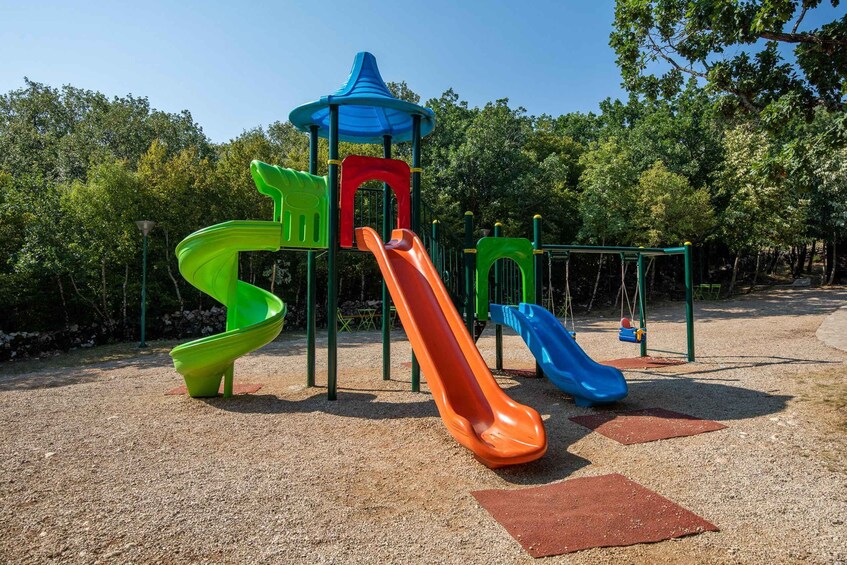 A playground with multiple slides and a climbing structure. 2