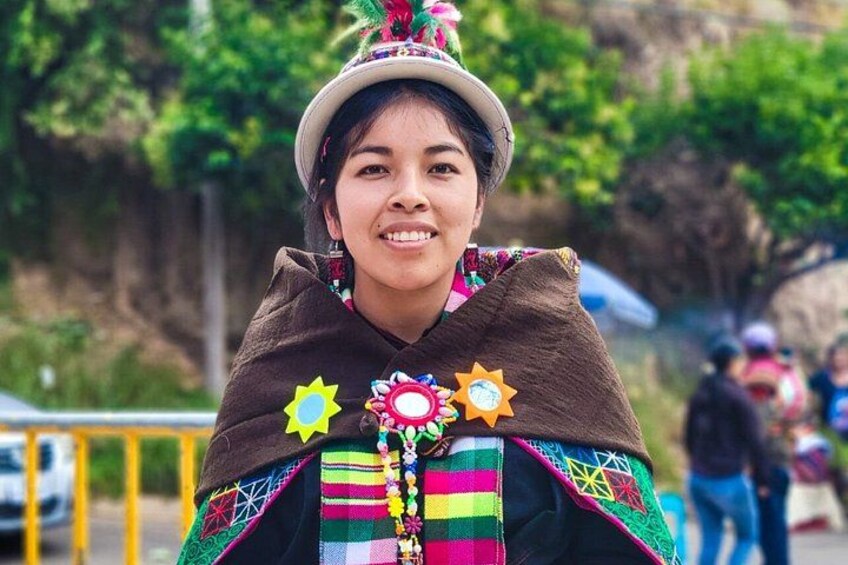 A person wearing a colorful traditional outfit with a patterned shawl and a decorative headpiece. 3