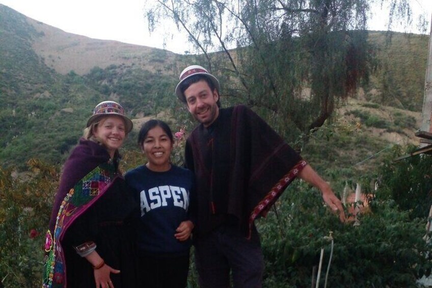 Trois personnes se trouvent à l'extérieur, avec un paysage montagneux en arrière-plan. 1