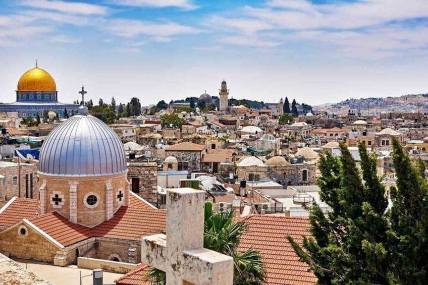 A cityscape with a prominent golden dome and a silver dome, surrounded by dense urban buildings. 4