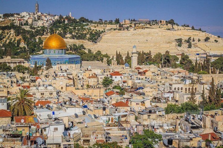 La Cúpula de la Roca, una cúpula dorada, y la Ciudad Vieja de Jerusalén con sus edificios históricos y calles serpenteantes. 1