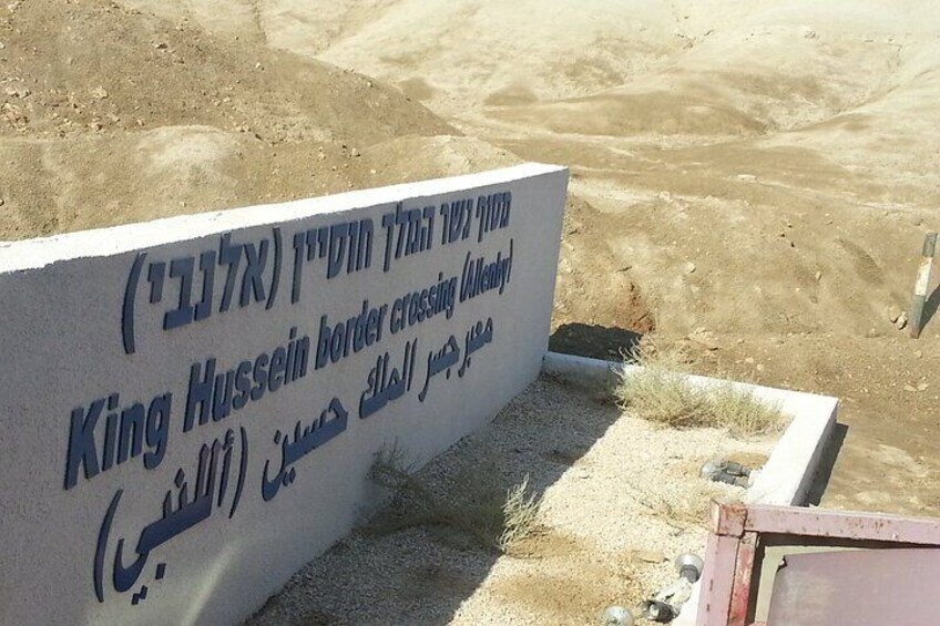 Un letrero con texto en varios idiomas en un paisaje desértico. 5