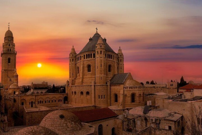 Un edificio histórico con una torre y una cúpula destacadas, frente a un cielo al atardecer. 3
